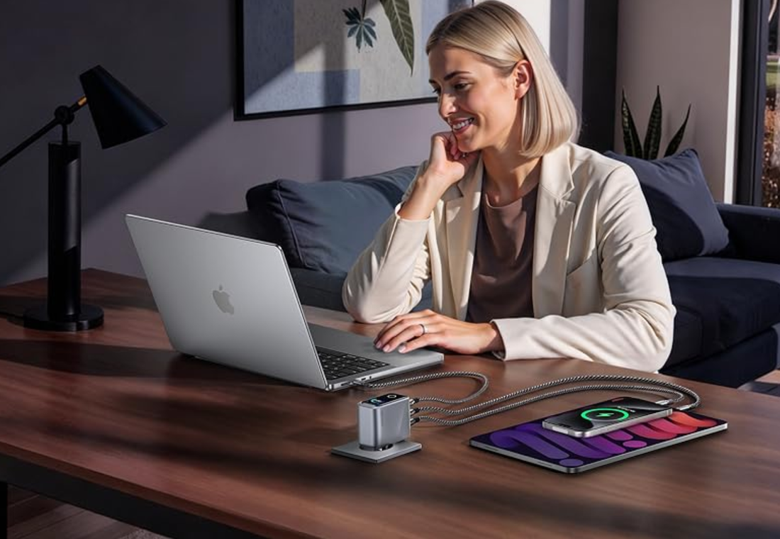 Person lädt Smartphone und Laptop am Schreibtisch mit Schnellladegerät, perfekt um das Handy richtig laden im Alltag zu optimieren.